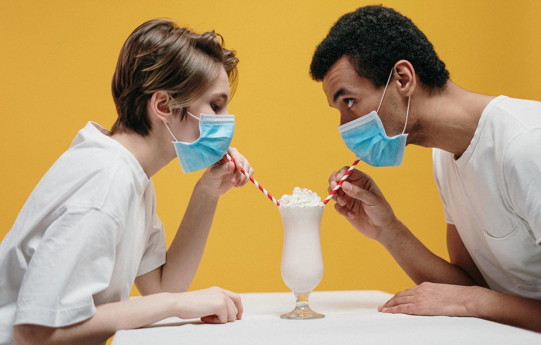 couple wearing face mask drinking milkshake